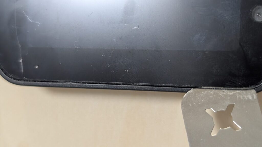 9：完全に金属のツールがディスプレイとフレームの間に挟まったら、深く刺しすぎないようにゆっくり金属のツールをディスプレイパネルを1周させるように回して粘着を切ります。2